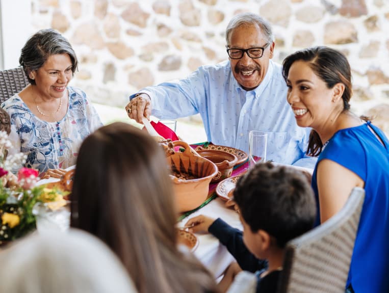 Family sitting down around the dinner table.