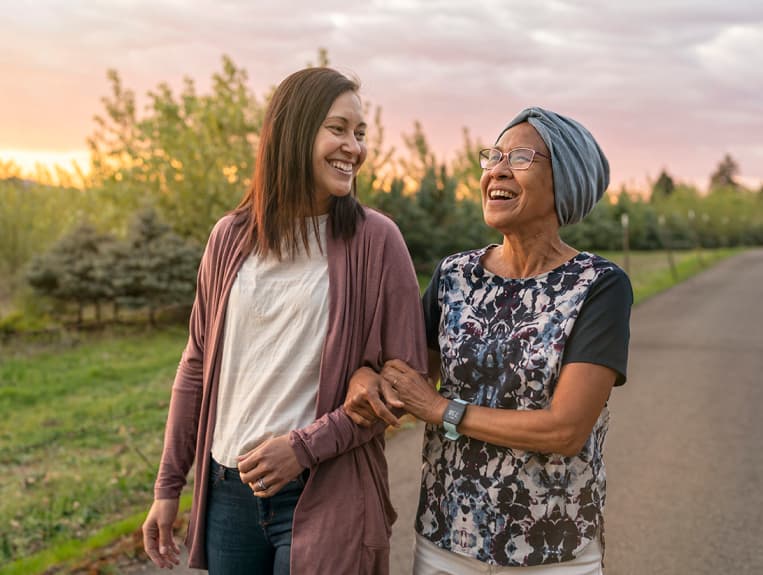 Woman walking down a path with an older woman