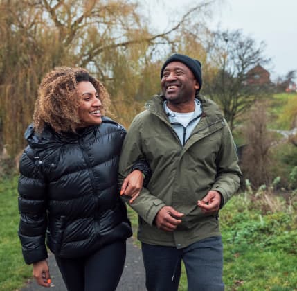 Woman walking arm-in-arm with man down a path.